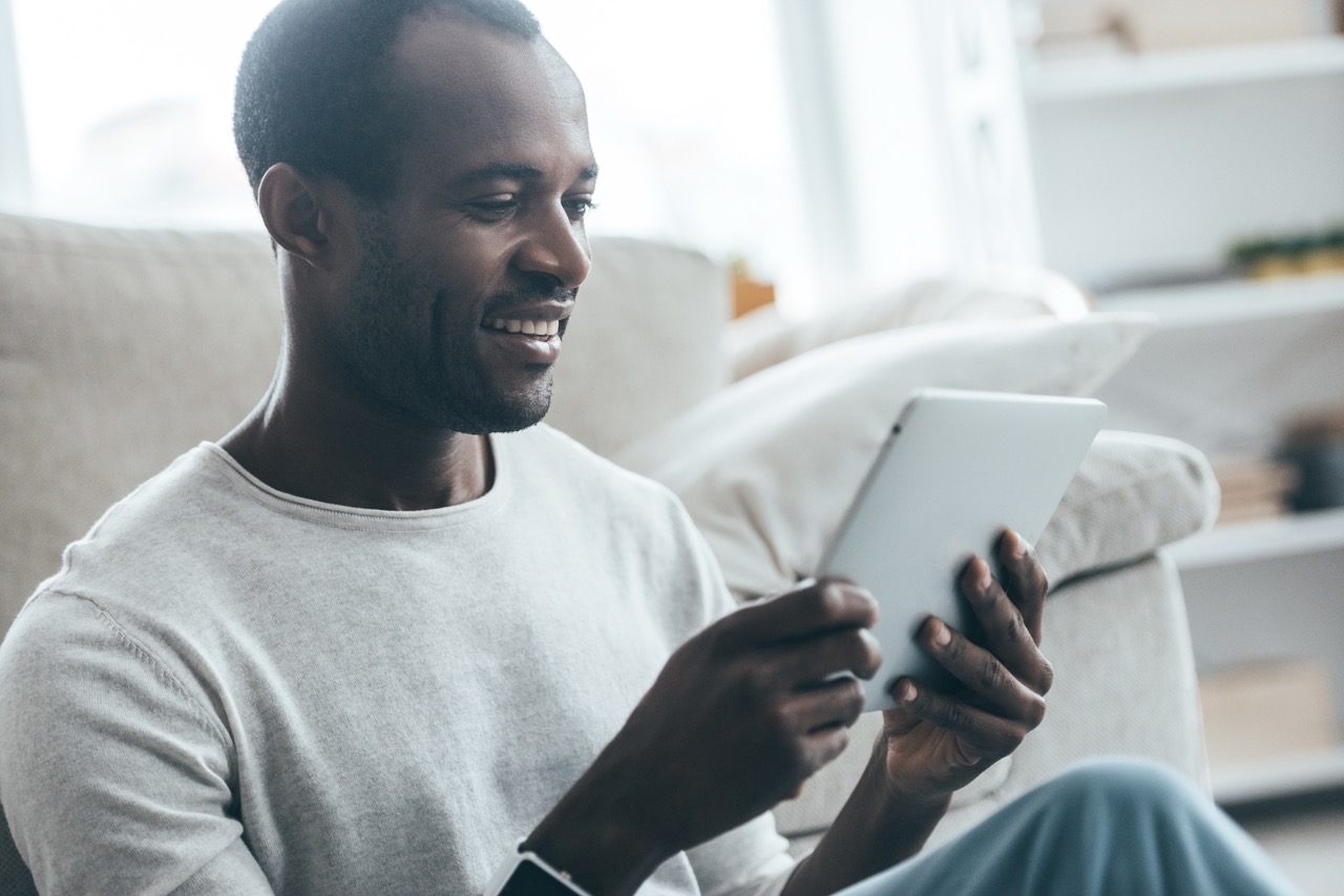 A person relaxing at home with a tablet, joining a session online